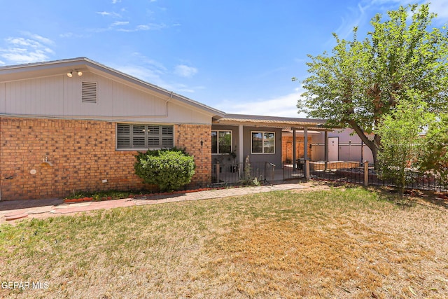 back of property with a lawn, brick siding, and fence private yard
