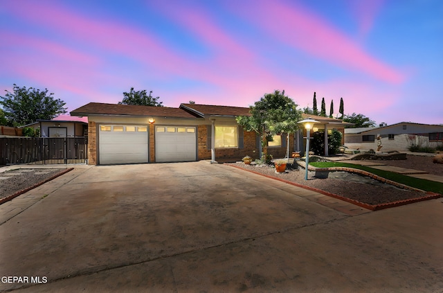 single story home featuring fence, an attached garage, concrete driveway, and brick siding