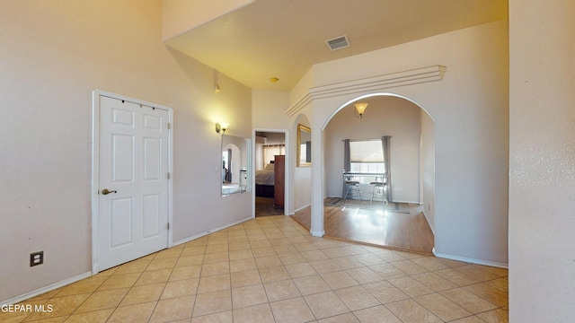 2088 Crystal Ridge St, El Paso, TX 79938 - foyer featuring light tile patterned flooring, arched walkways, baseboards, a towering ceiling, and visible vents