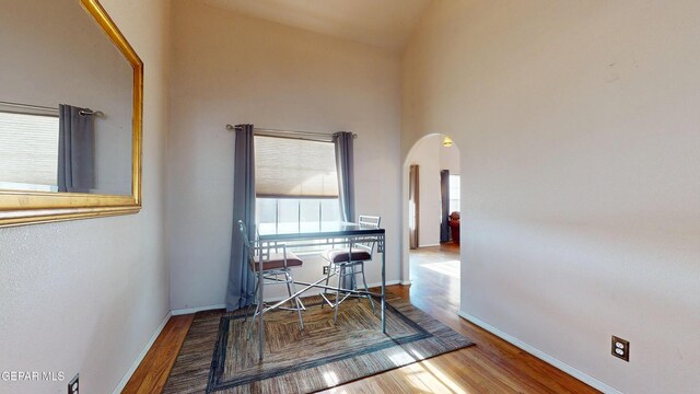 2088 Crystal Ridge St, El Paso, TX 79938 - hallway featuring arched walkways, baseboards, wood finished floors, and high vaulted ceiling