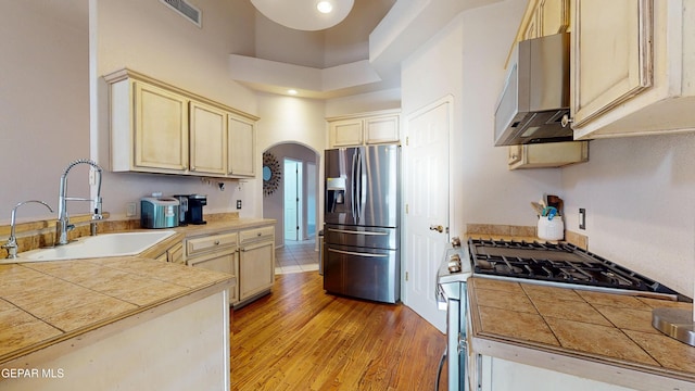 2088 Crystal Ridge St, El Paso, TX 79938 - kitchen with visible vents, arched walkways, a sink, light wood finished floors, and stainless steel appliances