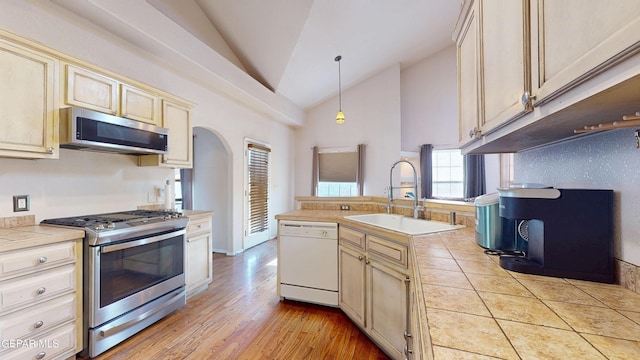2088 Crystal Ridge St, El Paso, TX 79938 - kitchen featuring a sink, arched walkways, tile counters, stainless steel appliances, and decorative light fixtures