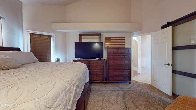 2088 Crystal Ridge St, El Paso, TX 79938 - bedroom featuring a barn door, carpet, and a high ceiling
