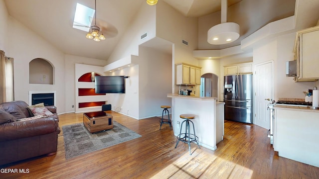 2088 Crystal Ridge St, El Paso, TX 79938 - living room with a high ceiling, a fireplace, wood finished floors, and visible vents