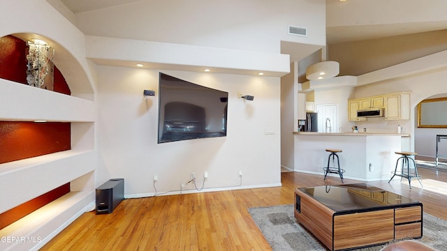 2088 Crystal Ridge St, El Paso, TX 79938 - living room with visible vents, light wood-type flooring, baseboards, high vaulted ceiling, and recessed lighting