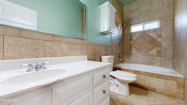 2088 Crystal Ridge St, El Paso, TX 79938 - bathroom with vanity, tile patterned flooring, toilet, tile walls, and tiled shower / bath combo
