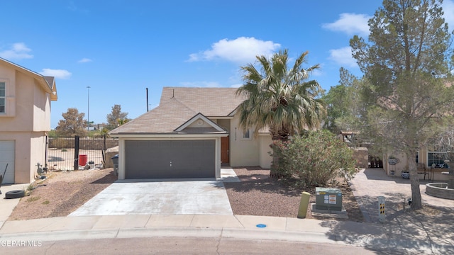 view of front of house with fence, a garage, stucco siding, and concrete driveway