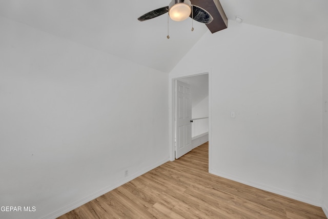 spare room with baseboards, light wood-style floors, beam ceiling, and a ceiling fan
