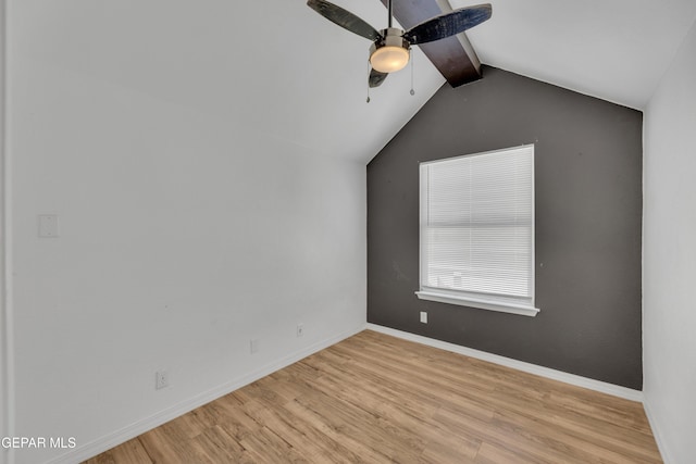 spare room with a ceiling fan, baseboards, vaulted ceiling with beams, and wood finished floors