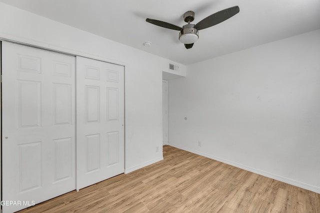 unfurnished bedroom with light wood-style flooring, a ceiling fan, a closet, visible vents, and baseboards