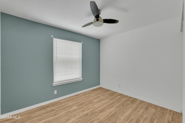 unfurnished room featuring a ceiling fan, baseboards, and wood finished floors