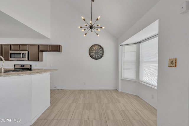 kitchen featuring a notable chandelier, dark brown cabinetry, decorative light fixtures, appliances with stainless steel finishes, and vaulted ceiling