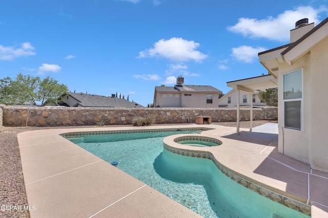 view of pool featuring a patio, a pool with connected hot tub, and a fenced backyard