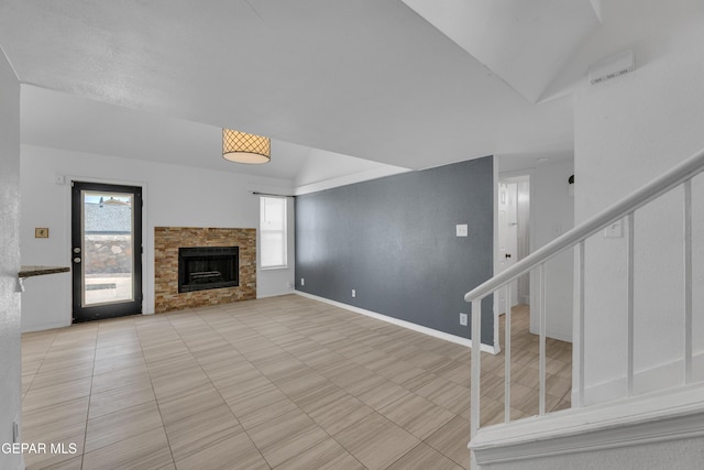 unfurnished living room featuring light tile patterned flooring, vaulted ceiling, stairway, baseboards, and a stone fireplace