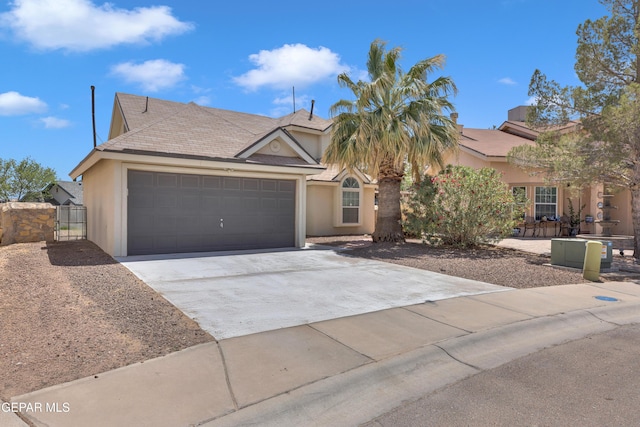 view of front of home featuring a gate, a garage, stucco siding, fence, and concrete driveway