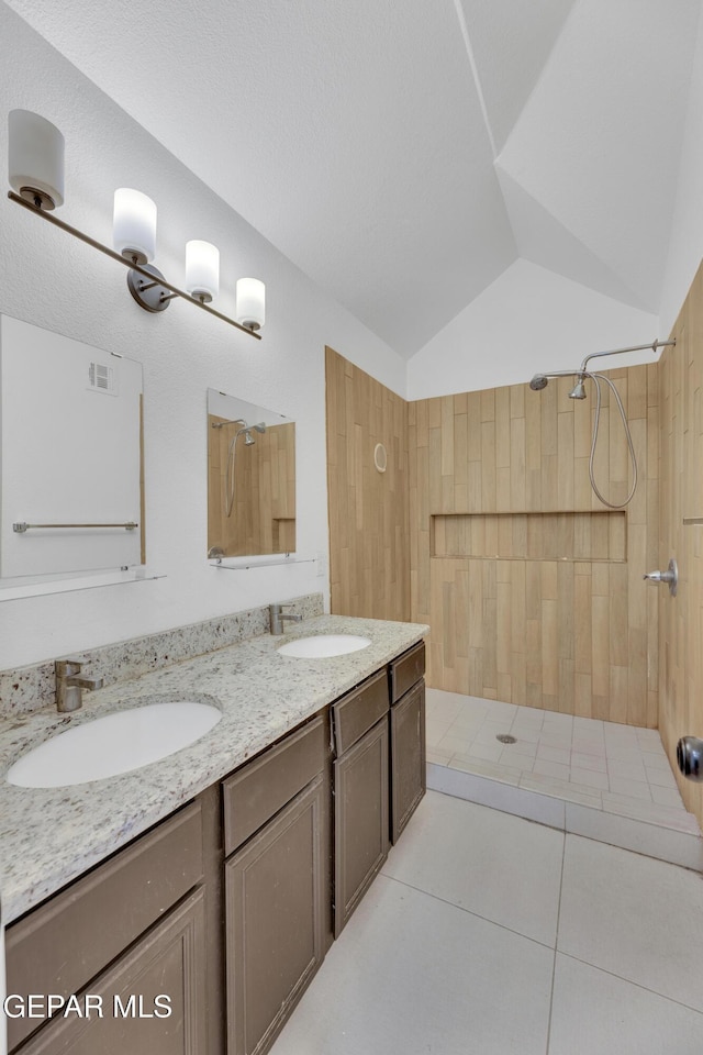 bathroom featuring visible vents, tiled shower, and a sink