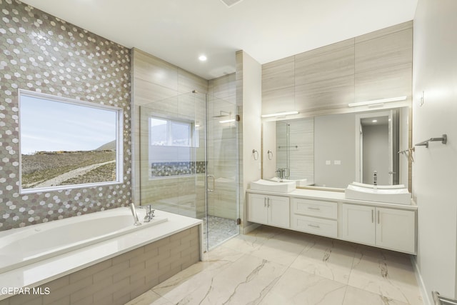 full bathroom featuring double vanity, marble finish floor, a bath, a sink, and a stall shower