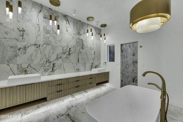 full bath with a freestanding bath, a marble finish shower, double vanity, and marble finish floor