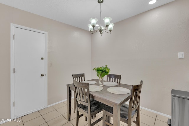 dining room featuring baseboards, light tile patterned floors, and an inviting chandelier