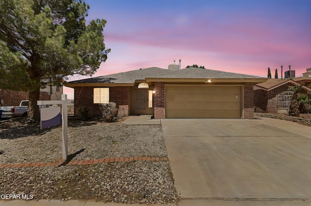 ranch-style home with driveway, a garage, and brick siding