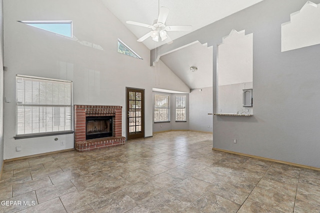 unfurnished living room with a ceiling fan, high vaulted ceiling, a healthy amount of sunlight, and baseboards