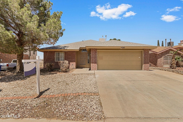 single story home with driveway, a garage, a shingled roof, and brick siding
