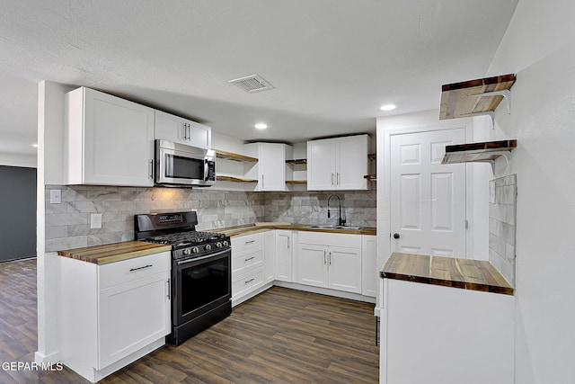 kitchen with wood counters, open shelves, appliances with stainless steel finishes, a sink, and visible vents