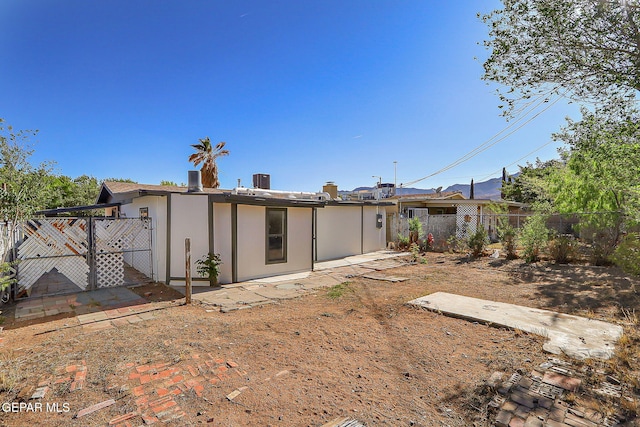 rear view of property with a gate and fence