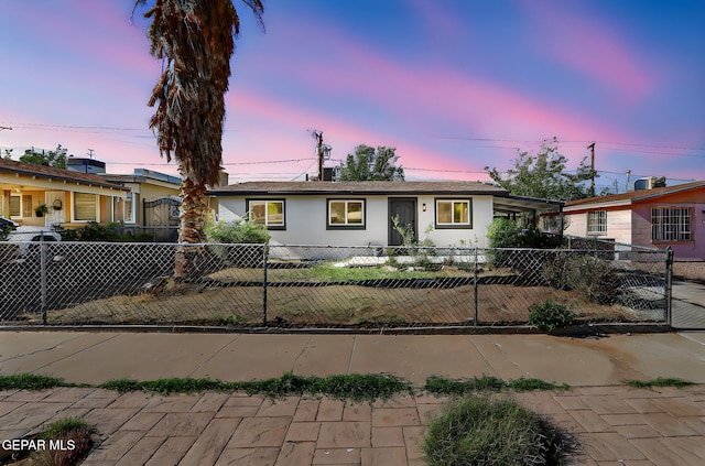 ranch-style house featuring stucco siding, a fenced front yard, and an attached carport