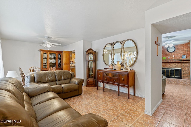 316 Garden Grove Ln, El Paso, TX 79912 - living area featuring a brick fireplace, a textured ceiling, ceiling fan, and baseboards