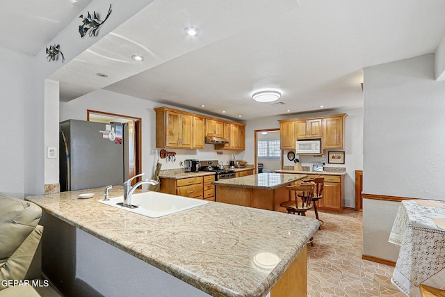 316 Garden Grove Ln, El Paso, TX 79912 - kitchen featuring a sink, under cabinet range hood, a peninsula, a kitchen island, and appliances with stainless steel finishes