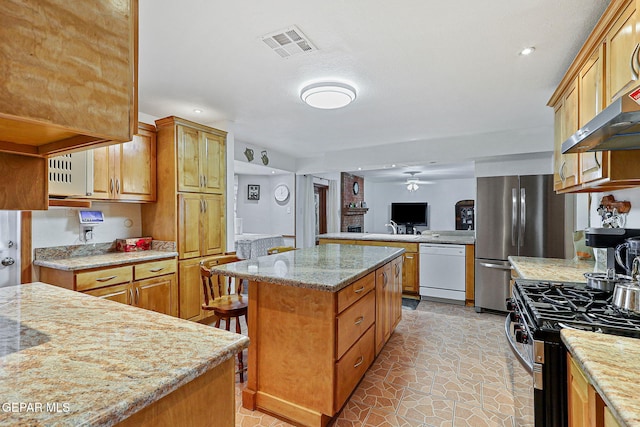 316 Garden Grove Ln, El Paso, TX 79912 - kitchen featuring light stone countertops, appliances with stainless steel finishes, a kitchen island, ceiling fan, and visible vents