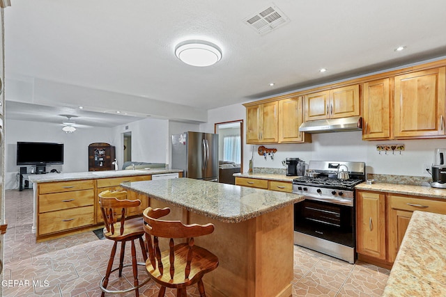 316 Garden Grove Ln, El Paso, TX 79912 - kitchen with stainless steel appliances, under cabinet range hood, ceiling fan, a center island, and visible vents