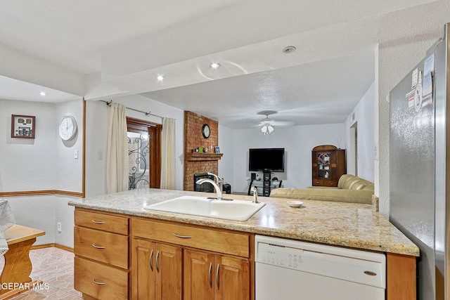 316 Garden Grove Ln, El Paso, TX 79912 - kitchen with a sink, a brick fireplace, ceiling fan, white dishwasher, and baseboards