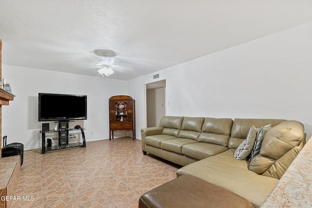 316 Garden Grove Ln, El Paso, TX 79912 - living room with light tile patterned floors, ceiling fan, baseboards, visible vents, and a textured ceiling