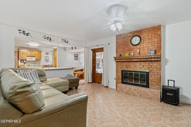 316 Garden Grove Ln, El Paso, TX 79912 - living room featuring a brick fireplace, a textured ceiling, and light tile patterned floors
