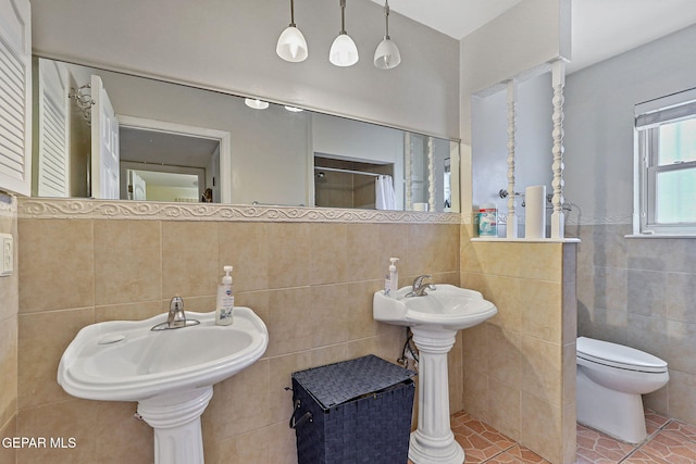 316 Garden Grove Ln, El Paso, TX 79912 - full bathroom featuring tile patterned floors, tile walls, a wainscoted wall, toilet, and curtained shower
