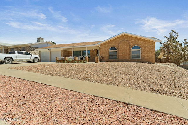 316 Garden Grove Ln, El Paso, TX 79912 - ranch-style home with covered porch, concrete driveway, brick siding, and a garage