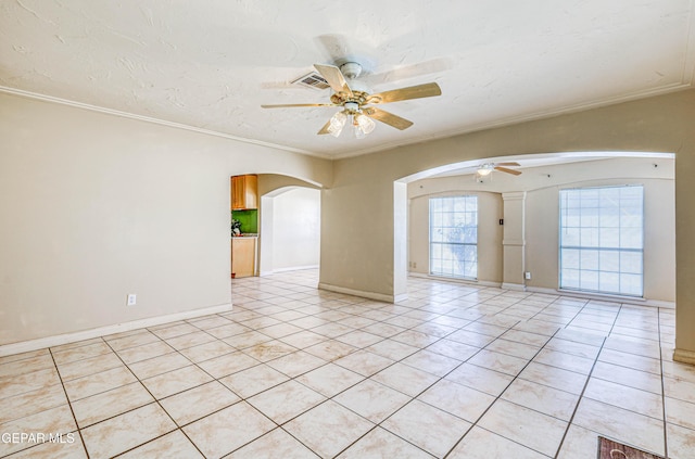 11144 Perlette St, Socorro, TX 79927 - unfurnished room featuring light tile patterned floors, a ceiling fan, baseboards, ornamental molding, and arched walkways