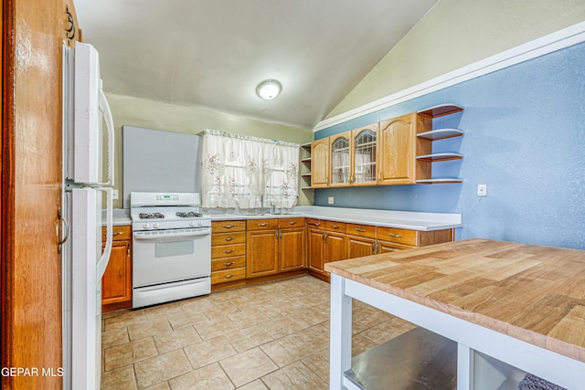 11144 Perlette St, Socorro, TX 79927 - kitchen with lofted ceiling, white appliances, open shelves, and light countertops
