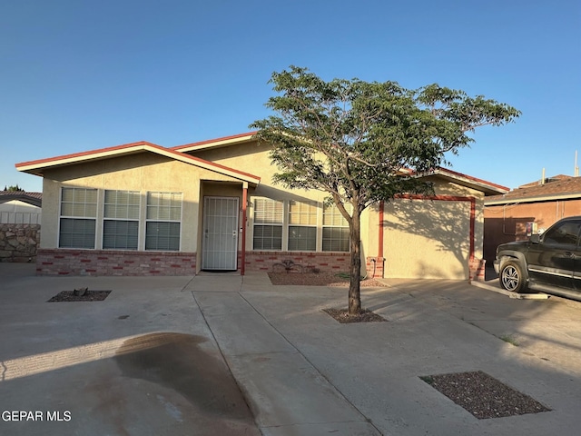 single story home with brick siding and stucco siding