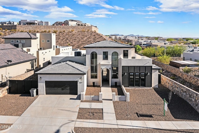 view of front of home featuring stucco siding, a residential view, concrete driveway, and an attached garage