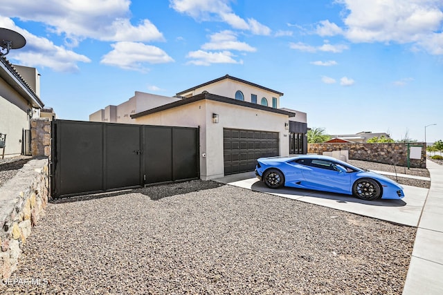 view of property exterior featuring driveway, a gate, stucco siding, and a garage
