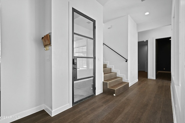 foyer featuring dark wood-style floors, baseboards, and stairs