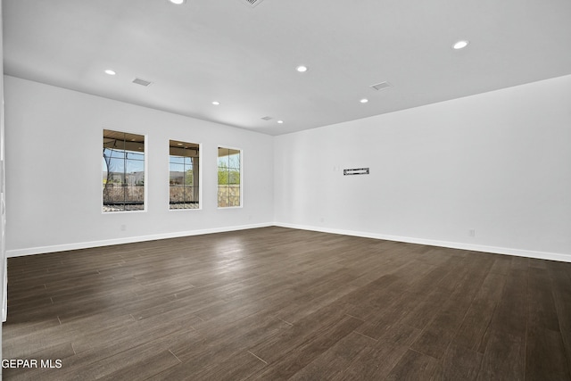spare room with dark wood finished floors, recessed lighting, visible vents, and baseboards