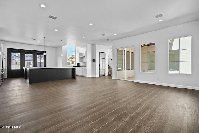 unfurnished living room featuring recessed lighting, visible vents, dark wood-style flooring, and baseboards