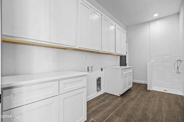 washroom with hookup for a washing machine, electric dryer hookup, cabinet space, dark wood-style flooring, and baseboards
