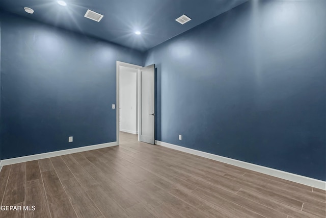 spare room with baseboards, visible vents, wood finished floors, and recessed lighting