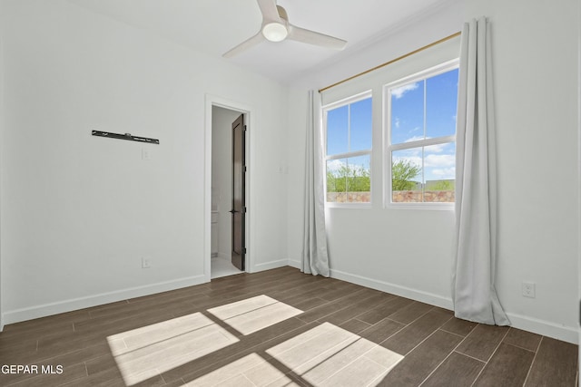 unfurnished room with ceiling fan, baseboards, and dark wood finished floors