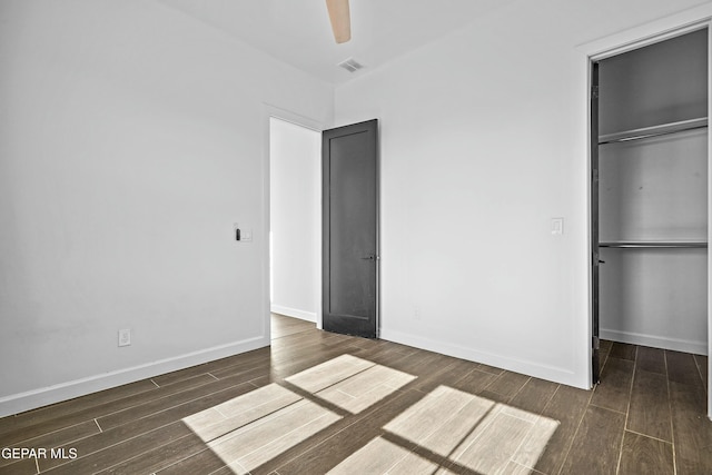 unfurnished bedroom featuring a closet, visible vents, wood finished floors, and baseboards